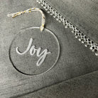 Decorative ornament with 'Joy' text on a textured surface